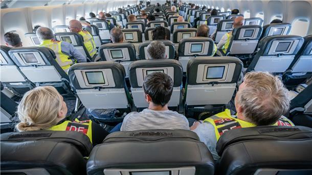 Sitzreihen mit Passagieren in einem Flugzeug