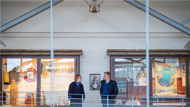 Oben an der Decke hängt die Klanginstallation in Form einer Schiffsglocke, die den Wellengang akustisch überträgt. Künstlerin Kira Keune übergibt das Kunstwerk an Kai Kähler, Leiter des Historischne Museums.