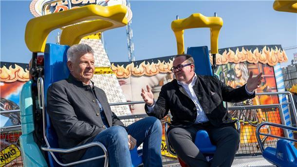 Wiesn startet - Fans reisen nach München Oberbürgermeister und Festleiter testen vor dem Start ein Fahrgeschäft.