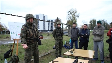 Oberfeldwebel Mariusz Starosz (l) erklärt auf einem Übungsplatz der polnischen Armee Bürgern den richtigen Umgang mit einer Handgranate.