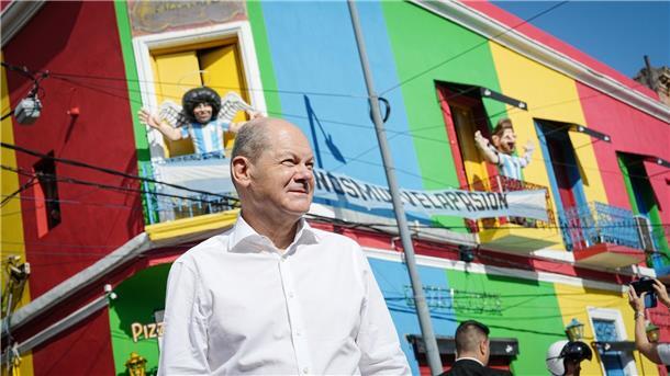 Olaf Scholz besucht in Buenos Aires den Stadtteil La Baco. Im Hintergrund eine Skulptur von Diego Maradona.