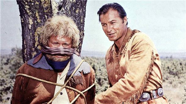 Ralf Wolter ist tot - Karl-May-Filme machten ihn berühmt Old Shatterhand (Lex Barker, r) hilft dem neugierigen Sam Hawkins (Ralf Wolter, l), von einem Marterpfahl loszukommen (1965).