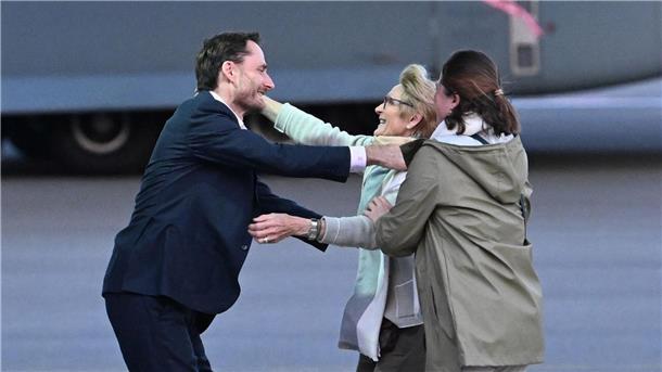 Olivier Vandecasteele (l) trifft seine Familie bei der Ankunft auf dem Militärflughafen Melsbroek.