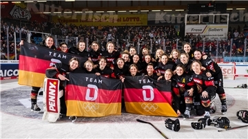 Olympia ruft: Die deutschen Eishockey-Frauen haben sich in Bremerhaven das Ticket gesichert und posieren vor den Fans, die sie lautstark unterstützt haben.