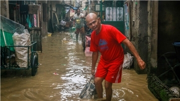 Opfer des Super-Taifuns Noru auf den  Philippinen reinigen ihre Häuser nach den starken Regenfällen.