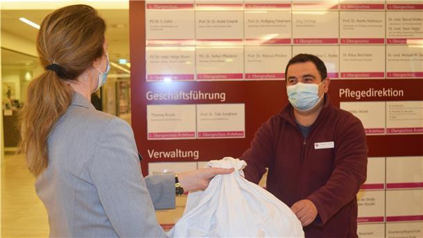 Orlando Horvat, Mitarbeiter des KBR, nimmt am Service-Punkt ein Paket für einen Patienten entgegen.