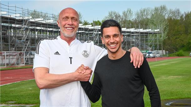 Zwei Fußballer klatschen ab. OSC-Sportleiter Björn Böning begrüßt den neuen Trainer Angelo Pauls.