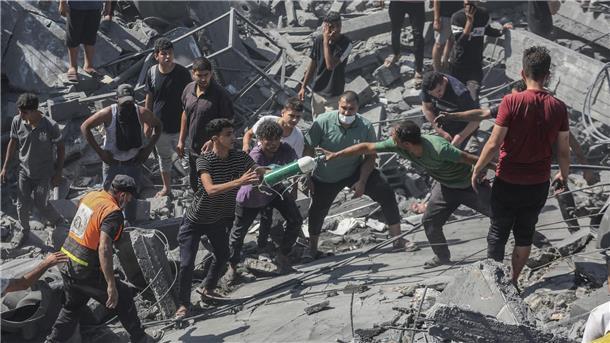 Palästinenser durchsuchen die Trümmer eines Gebäudes in Chan Yunis, das bei einem israelischen Luftangriff zerstört wurde.