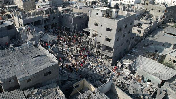 Palästinenser durchsuchen die Trümmer nach einem israelischen Bombardement im Flüchtlingslager Al-Magasi im Gazastreifen.