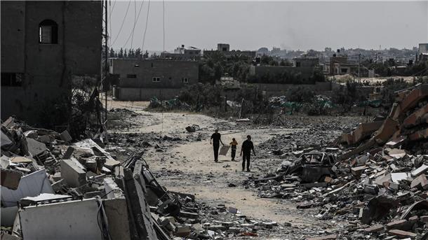 Erneut schwere Kämpfe im Norden Gazas Palästinenser gehen neben zerstörten Wohngebäuden im Lager Nuseirat im zentralen Gazastreifen entlang.