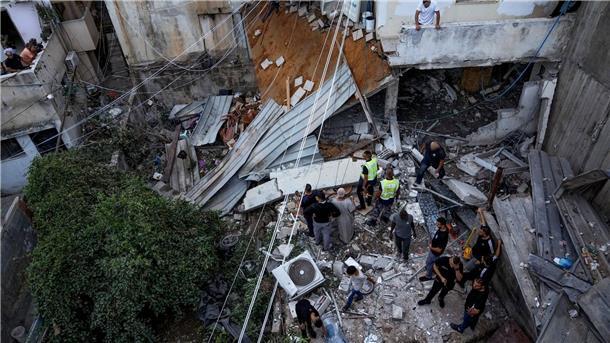 Wieder Unruhen: Israel greift an Gaza-Grenze Hamas-Posten an Palästinenser inspizieren nach dem Einsatz der israelischen Armee ein beschädigtes Gebäude.