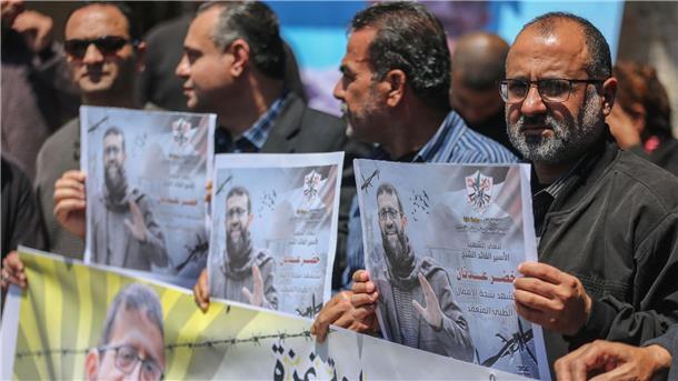 Palästinenser mit Plakaten von Chader Adnan in Gaza-Stadt.