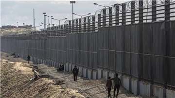 Palästinenser stehen nahe der Grenze zwischen dem Gazastreifen und Ägypten.