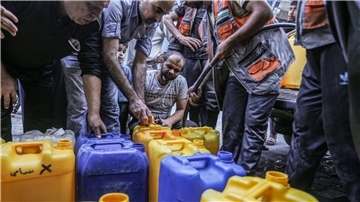 Palästinenser stehen Schlange, um Wasser zu bekommen.