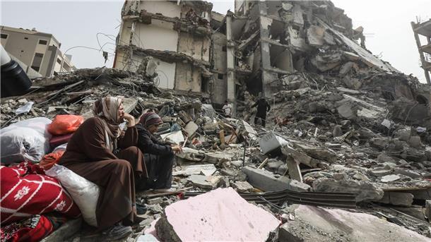 Hamas stimmt einer Waffenruhe im Gazastreifen zu Palästinenserinnen sitzen auf Trümmern im Flüchtlingslager Nuseirat im Gazastreifen nach dem Abzug der israelischen Streitkräfte (IDF).