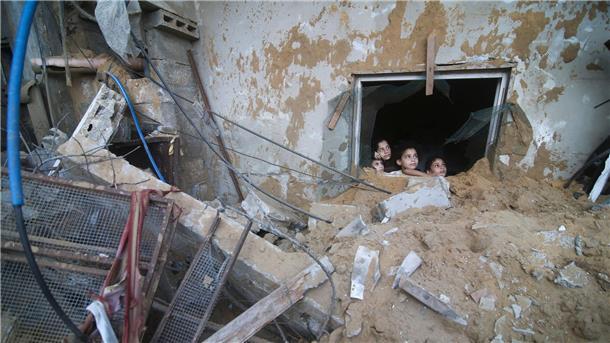 Palästinensische Kinder schauen in Rafah im Süden des Gazastreifens aus einem Fenster, das bei israelischen Luftangriffen zerstört wurde.