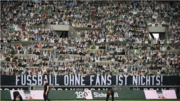 Pappaufsteller stehen statt der Fans auf der Tribüne, an der ein Banner mit der Aufschrift „Fussball ohne Fans ist nichts!"