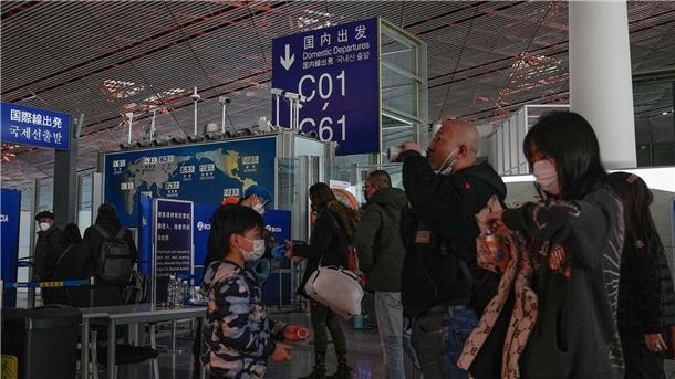 Covid-Test bei Einreise aus China: Wie geht Deutschland vor? Passagiere mit Mund-Nasen-Schutz stehen am Flughafen Peking an der Sicherheitskontrolle vor einem internationalen Abfluggate an.