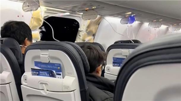 Handy aus havariertem Flieger übersteht 5000-Meter-Sturz Passagiere sitzen in einer Boeing 737-9 Max in der Nähe des abgerissenen Kabinenteils.