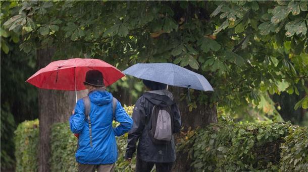 Abschied vom Sommer mit durchwachsenem Wetter Passanten mit Regenschirmen in Moritzburg in Sachsen.