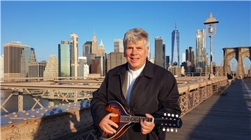 Pastor Klaus Gress mit seiner Mandoline auf der Brooklyn Bridge. Für seine Gemeinde in New York bleibt er immer ansprechbar.
