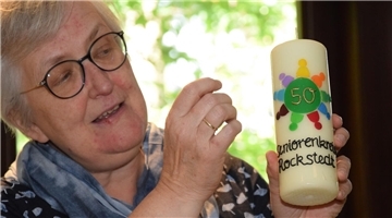 Pastorin Petra Lemmel überreichte zum 50. Geburtstag des Seniorenkreises eine Kerze mit passendem Motiv.