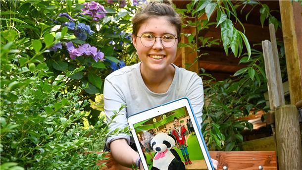 Eine Frau präsentiert ein Bild von sich.