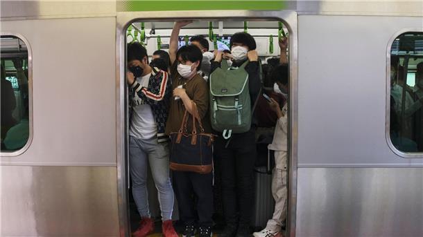 Japanisches Mädchen spielt U-Bahn-Fahrerin - Züge verspätet Pendler drängen sich in Tokio in einen Waggon (Symbolbild).
