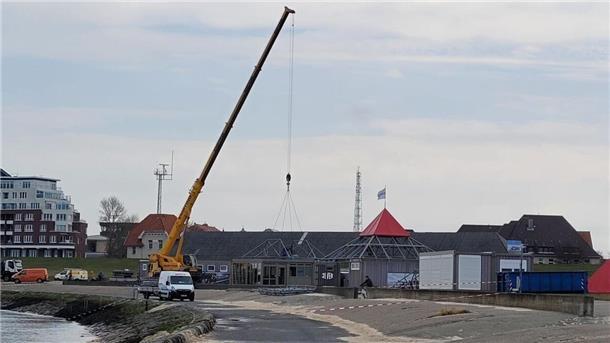 Ein Kran bringt Pavillons in der Grimmershörnbucht in Cuxhaven an ihre Plätze. Bald beginnt die Badesaison, die Strände öffnen.