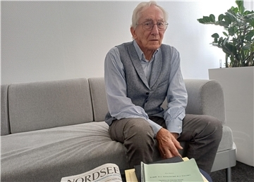 Ein alter Mann schaut in die Kamera.