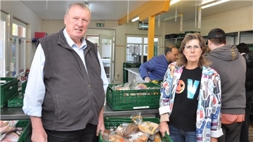 Ein Mann und eine Frau bei der Lebensmittelausgabe der Nordenhamer Tafel