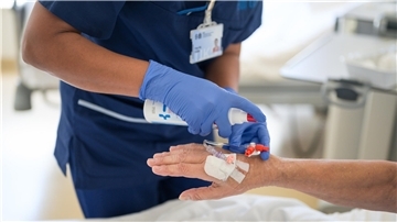 Eine Pflegekraft legt einer Patientin eine Infusion. 