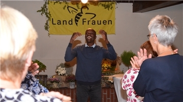 Philip Oprong Spenner aus Kenia, heute Lehrer in Hamburg, bringt die Landfrauen nach der Kaffeetafel mit kleinen Übungen in Schwung, bevor er über sein enorm ungewöhnliches Leben erzählt.