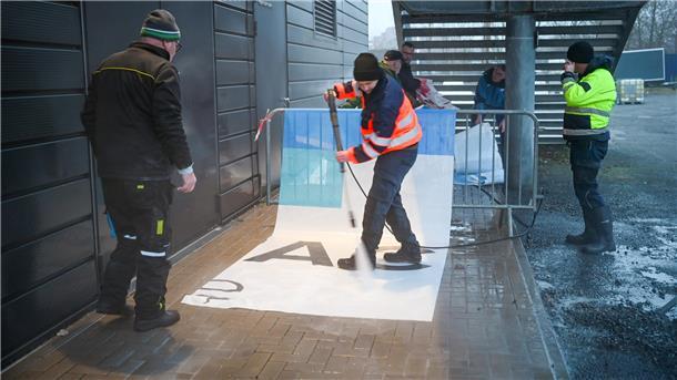 Pinguins-Fans reinigen als freiwillige Helfer die Werbefolien, die nach dem Abtauen des Arena-Eises verschmutzten.