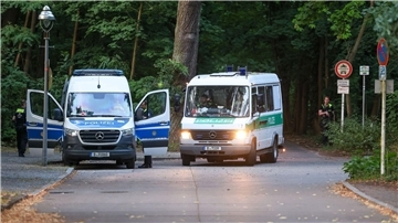 Polizeiautos fahren aus dem Wald in dem sich die Raubkatze befinden soll.