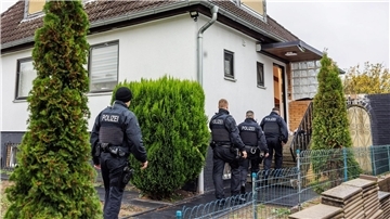 Polizeibeamte durchsuchen ein Haus in einer Wohnsiedlung in Garbsen.