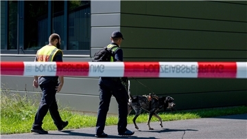 Polizeibeamte ermitteln mit einem Spürhund am Schulzentrum in Lohr am Main, wo der tote 14-Jährige gefunden wurde.