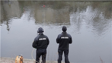 Polizeibeamte sichern vom Ufer aus einen Tauscher.
