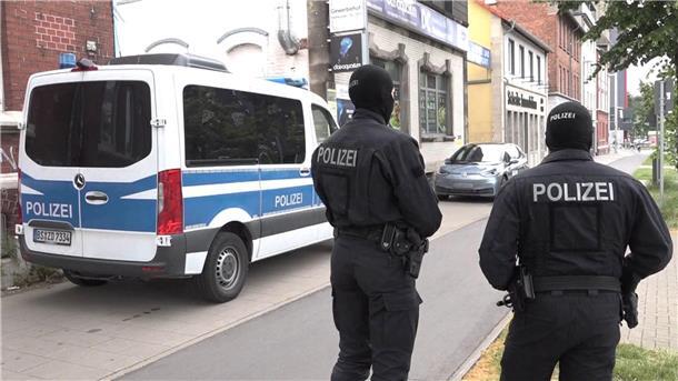 Polizeibeamte stehen vor einem der durchsuchten Objekte in Braunschweig.
