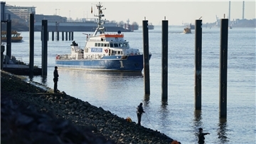 Polizeitaucher und Polizeibeamte bei der Suche nach dem Jungen in der Elbe.