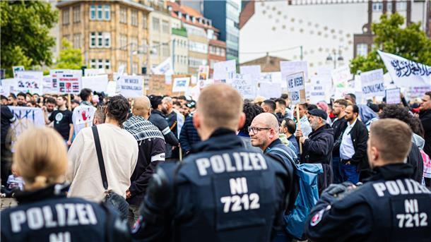 Behrens will Forderung nach Kalifat verbieten Polizisten beobachten zahlreiche Demonstranten.