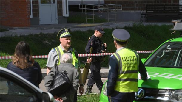 Kreml macht Kiew für Drohnenangriffe verantwortlich Polizisten bewachen einen Bereich, in dem Berichten zufolge eine ukrainische Drohne ein Wohnhaus beschädigt haben soll.