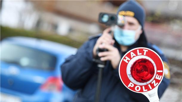 Polizisten blitzen Autofahrer, die mit überhöhter Geschwindigkeit unterwegs sind, in der Nähe einer Schule.