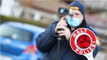 Polizisten blitzen Autofahrer, die mit überhöhter Geschwindigkeit unterwegs sind, in der Nähe einer Schule.