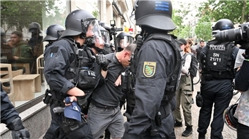 Polizisten halten einen Teilnehmer aus einer Demonstration in Leipzig fest.