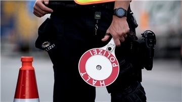 Polizisten kontrollieren an einem Grenzgebiet.
