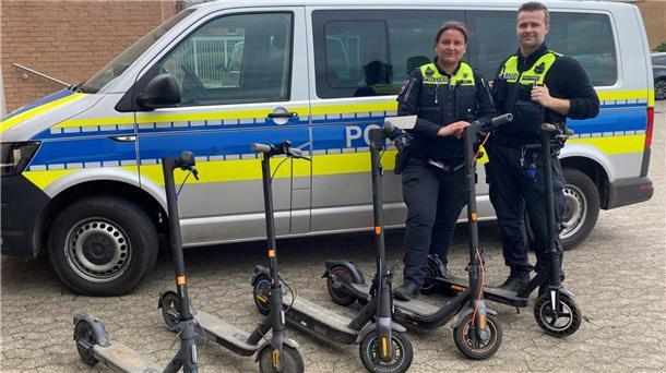 Polizisten präsentieren die sichergestellten, mutmaßlich geklauten E-Scooter.