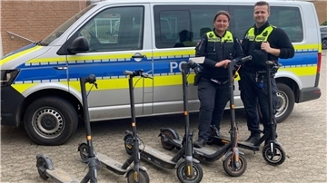 Polizisten präsentieren die sichergestellten, mutmaßlich geklauten E-Scooter.