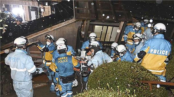 Polizisten retten im japanischen Suzu eine Frau aus einem eingestürzten Haus.