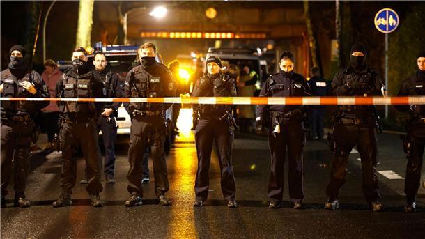 Polizisten stehen an einer Absperrung nahe der Unfallstelle.